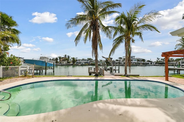 pool featuring a water view, boat lift, a dock, and fence