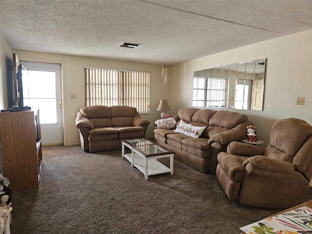 living area featuring carpet flooring, plenty of natural light, visible vents, and a textured ceiling