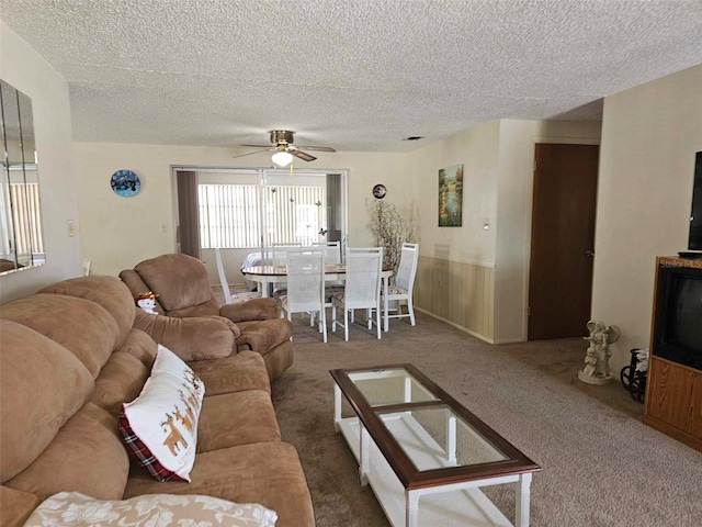 living room with carpet floors, a textured ceiling, and a ceiling fan