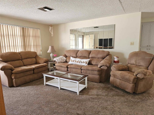 living room featuring visible vents, a textured ceiling, and carpet flooring