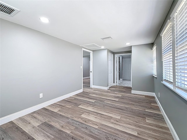 spare room with visible vents, baseboards, and wood finished floors