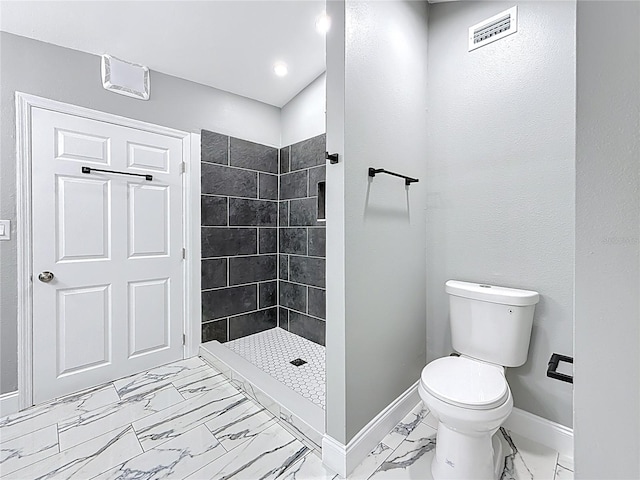 bathroom with visible vents, baseboards, toilet, a tile shower, and marble finish floor