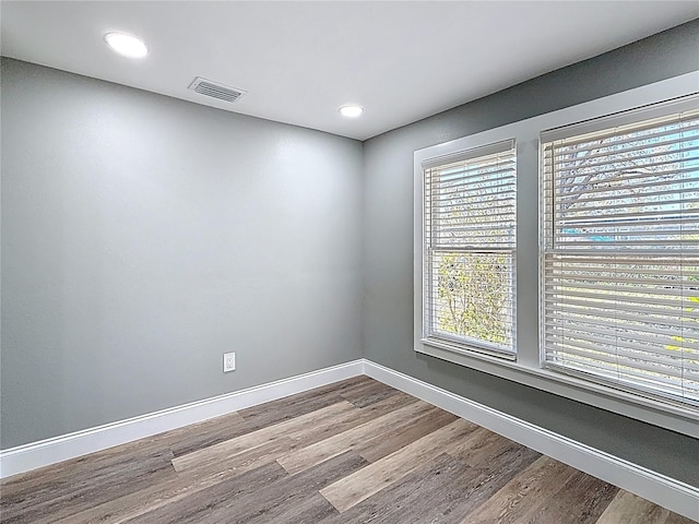 unfurnished room with visible vents, recessed lighting, baseboards, and wood finished floors