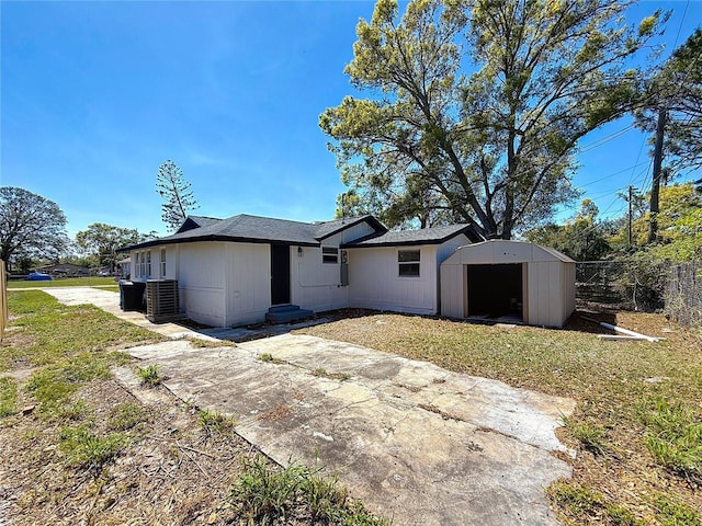 rear view of property featuring a yard, fence, an outbuilding, and a shed