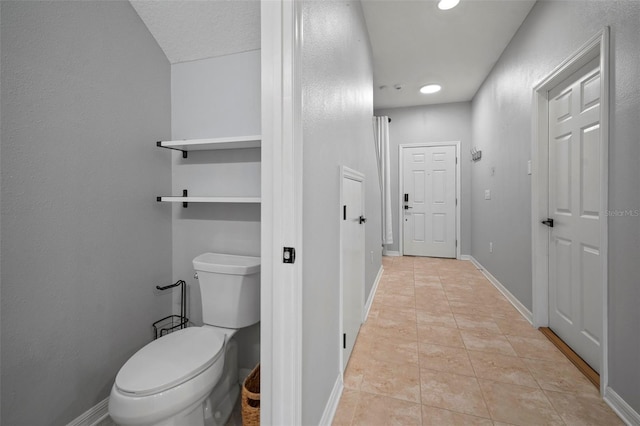 bathroom with tile patterned floors, toilet, and baseboards