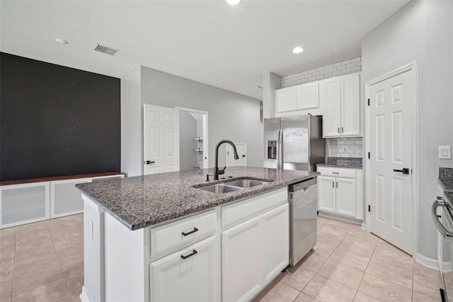 kitchen with visible vents, a sink, stainless steel appliances, white cabinetry, and a kitchen island with sink