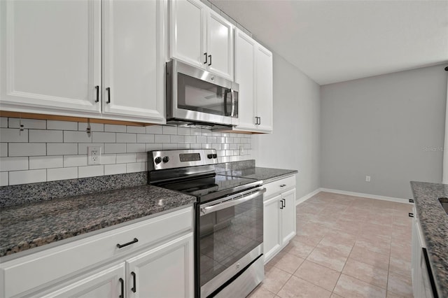 kitchen featuring decorative backsplash, dark stone counters, white cabinetry, and stainless steel appliances