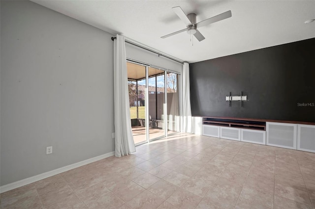 spare room featuring baseboards and a ceiling fan