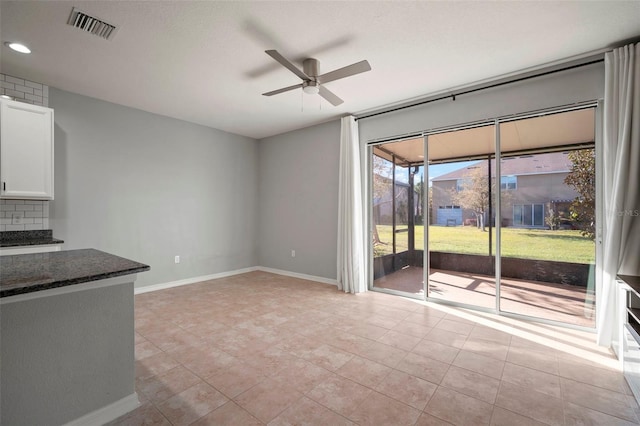 interior space with light tile patterned floors, visible vents, baseboards, and a ceiling fan