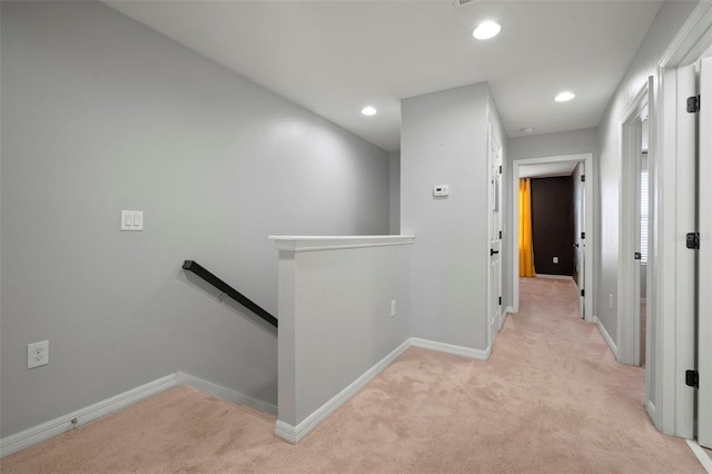 hall featuring an upstairs landing, recessed lighting, light carpet, and baseboards