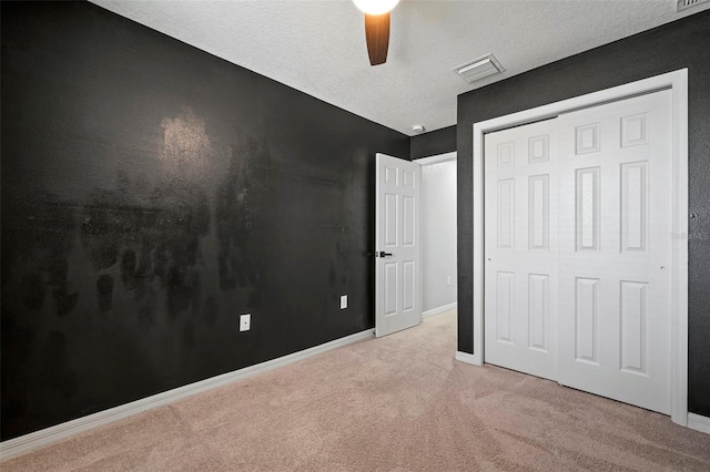 unfurnished bedroom featuring baseboards, visible vents, carpet floors, a closet, and a textured ceiling