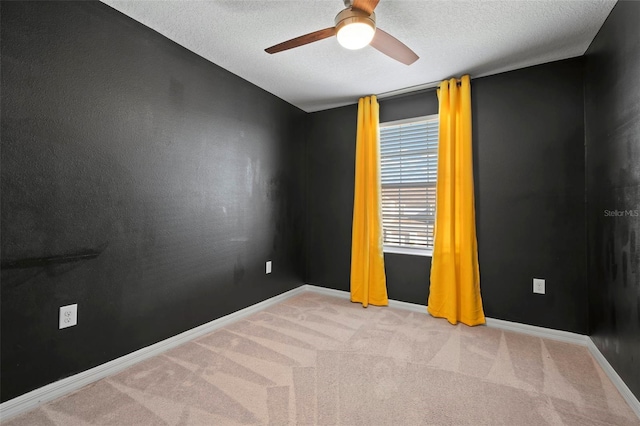 spare room featuring a textured ceiling, baseboards, ceiling fan, and carpet floors