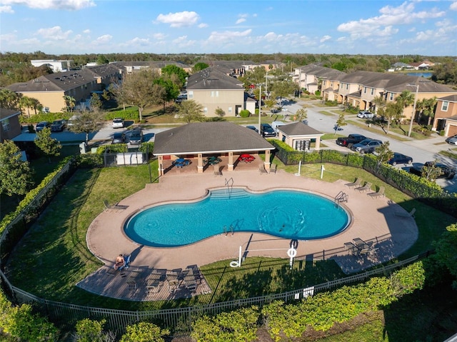 pool featuring fence, a patio area, and a residential view