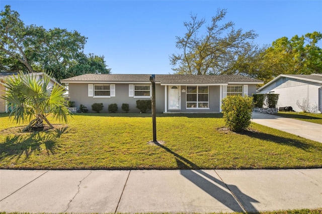 ranch-style house with concrete driveway and a front lawn