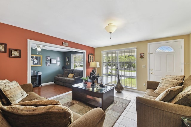 tiled living area featuring baseboards and ceiling fan