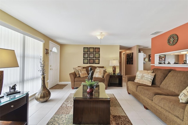 living room with light tile patterned floors, visible vents, and a healthy amount of sunlight