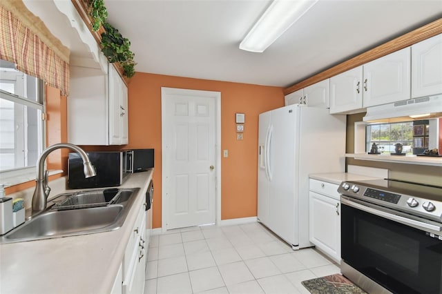 kitchen featuring under cabinet range hood, stainless steel electric range oven, white refrigerator with ice dispenser, white cabinets, and a sink