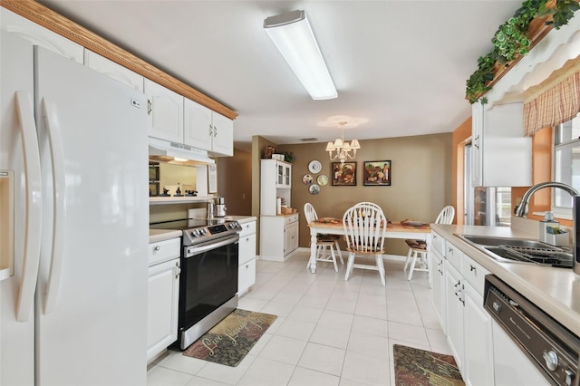 kitchen featuring a chandelier, white appliances, light countertops, and a sink