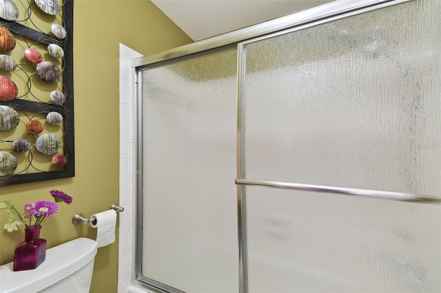 bathroom with an enclosed shower and toilet