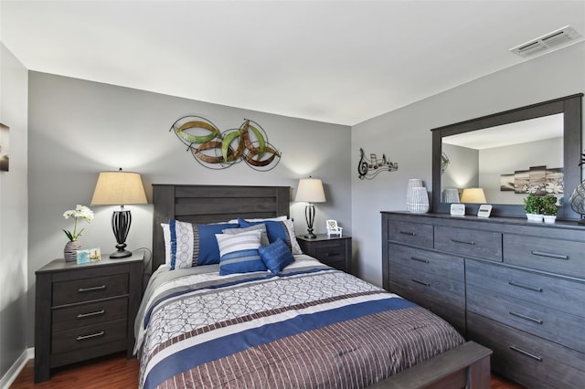 bedroom with visible vents and dark wood-type flooring