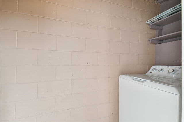 laundry area with washer / dryer, concrete block wall, and laundry area