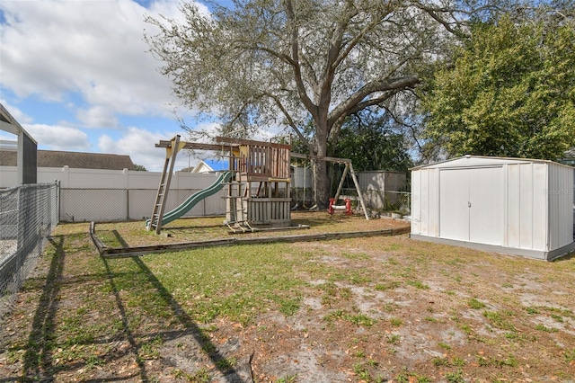 view of yard with an outdoor structure, a playground, a fenced backyard, and a shed