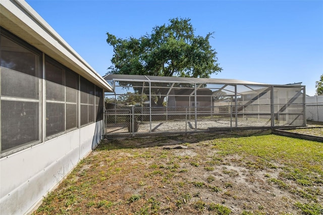 view of yard with a lanai and fence