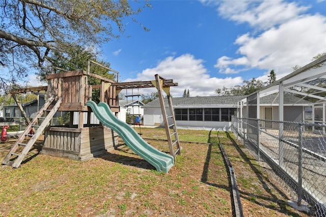 view of playground with a lawn and fence