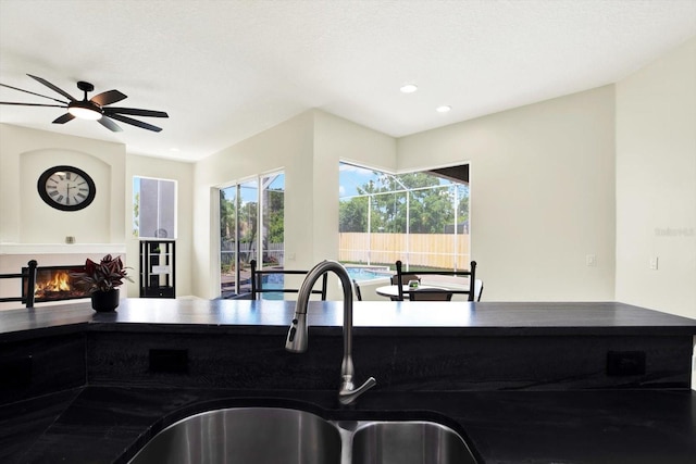 kitchen with plenty of natural light, a sink, recessed lighting, and dark countertops