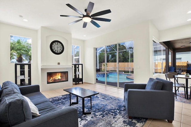 living area featuring tile patterned floors, a healthy amount of sunlight, and ceiling fan