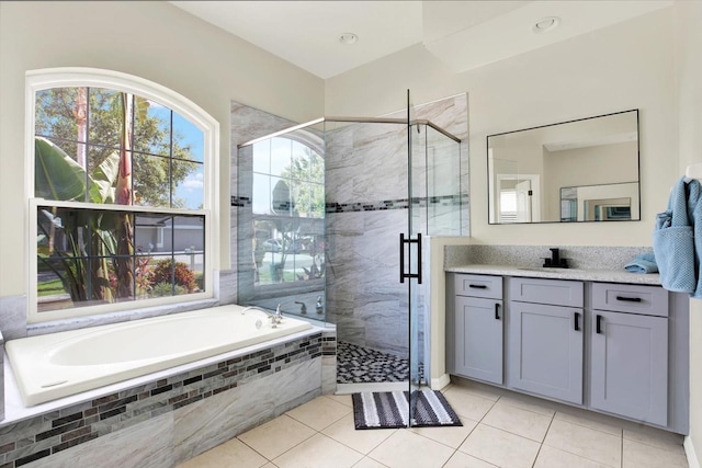 full bath featuring tile patterned flooring, a shower stall, a garden tub, and vanity