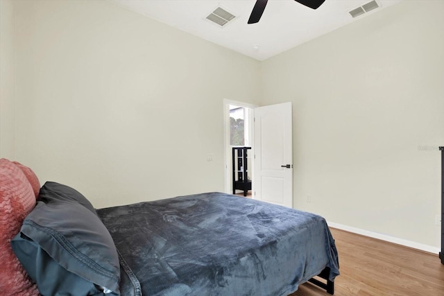bedroom featuring visible vents, a ceiling fan, baseboards, and wood finished floors