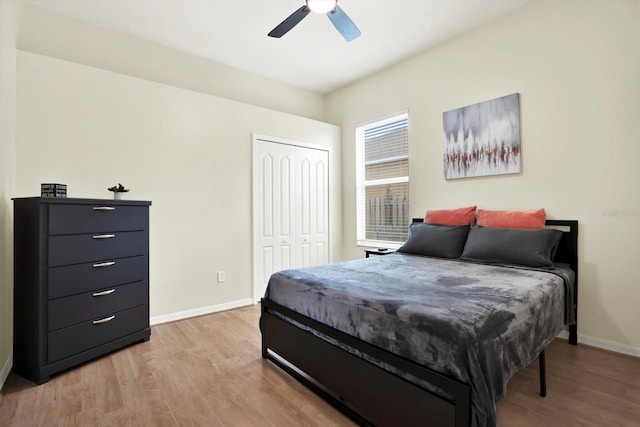 bedroom with light wood-type flooring, baseboards, ceiling fan, and a closet