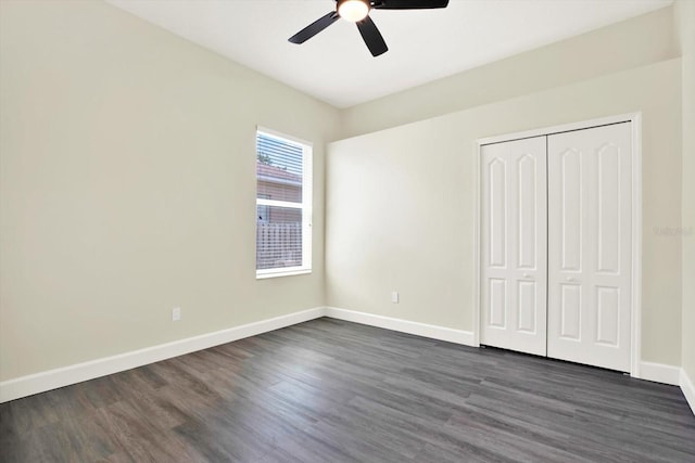 unfurnished bedroom with a closet, baseboards, a ceiling fan, and dark wood-type flooring