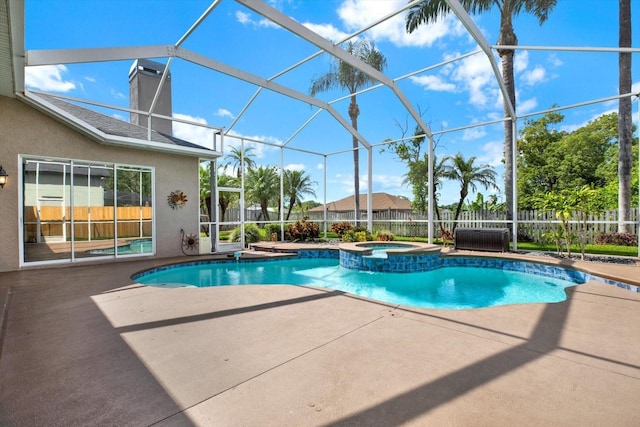 view of swimming pool featuring fence, glass enclosure, a pool with connected hot tub, and a patio area