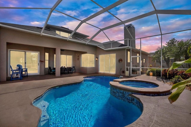 view of swimming pool featuring a pool with connected hot tub, a lanai, and a patio area