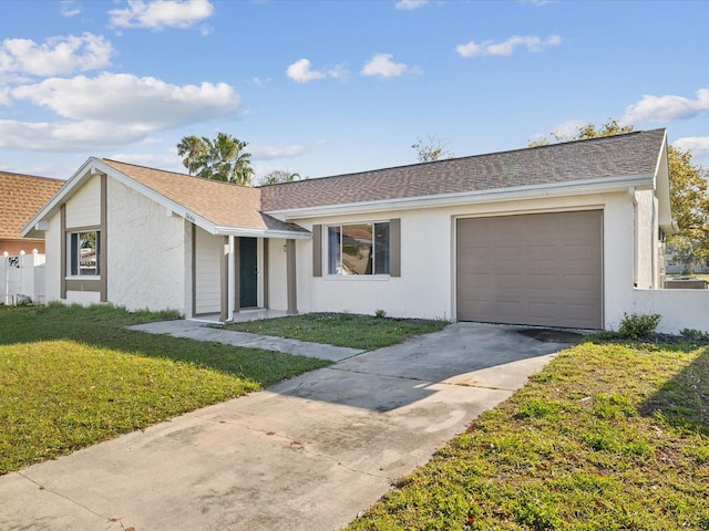 single story home with a front lawn, an attached garage, driveway, and stucco siding