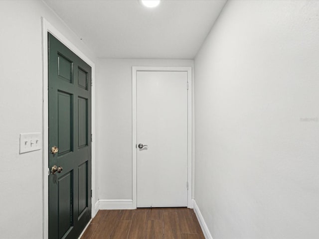 foyer with baseboards and dark wood-type flooring