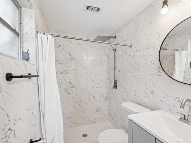 bathroom featuring vanity, a shower stall, toilet, and visible vents