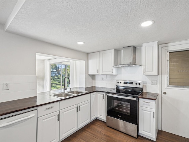 kitchen featuring dark wood finished floors, a sink, electric stove, dishwasher, and wall chimney exhaust hood