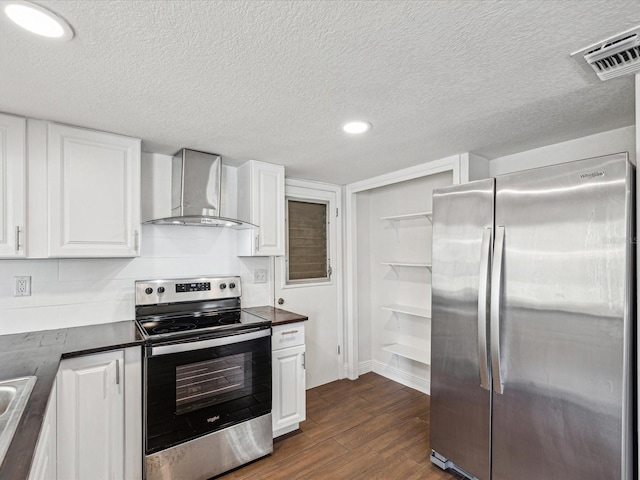 kitchen featuring visible vents, dark countertops, dark wood-style floors, stainless steel appliances, and wall chimney exhaust hood