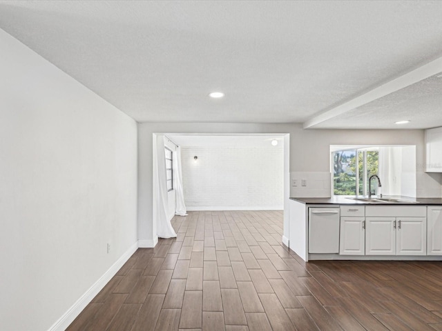 kitchen with dark wood-style flooring, white cabinets, white dishwasher, and a sink