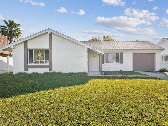 single story home featuring concrete driveway, a garage, a front yard, and stucco siding