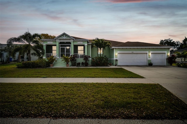 view of front of home with concrete driveway, a lawn, and a garage