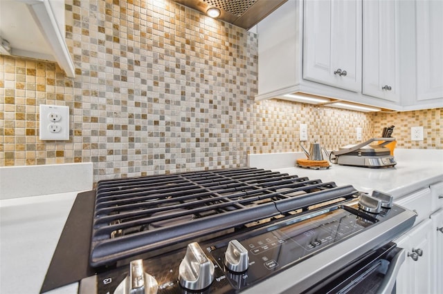 details featuring cooktop, tasteful backsplash, light countertops, and white cabinetry