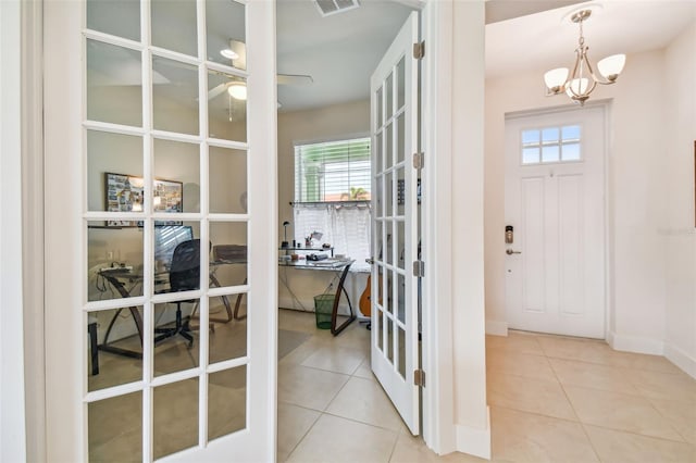 entryway with tile patterned flooring, ceiling fan with notable chandelier, visible vents, and french doors