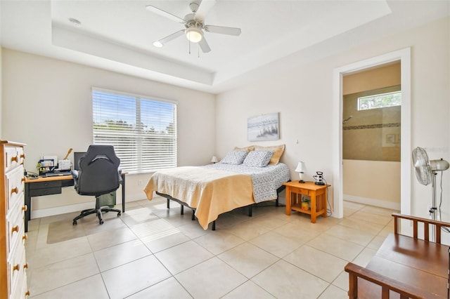 bedroom with light tile patterned flooring, a ceiling fan, a raised ceiling, and baseboards