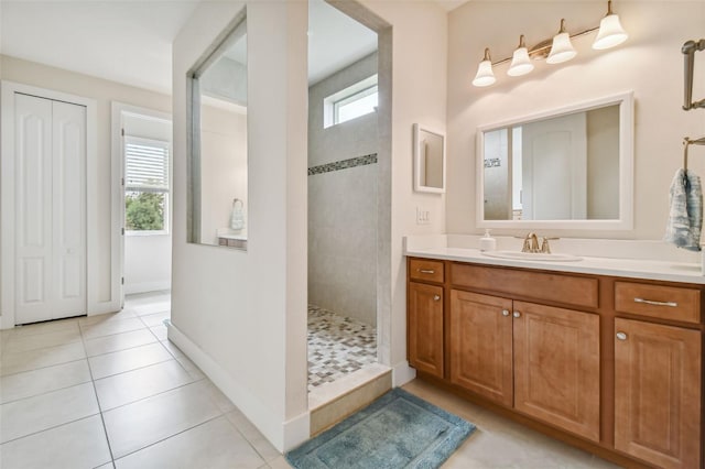 full bath with tile patterned flooring, vanity, a wealth of natural light, and walk in shower