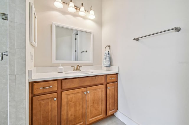 full bathroom featuring vanity, tile patterned floors, baseboards, and a tile shower