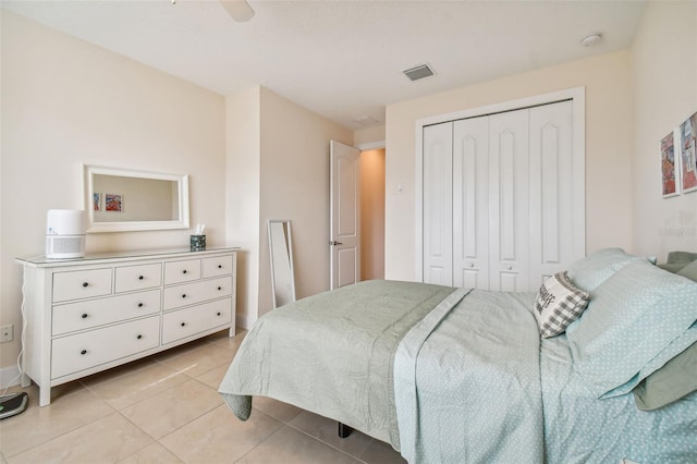 bedroom with a closet, visible vents, ceiling fan, and light tile patterned floors